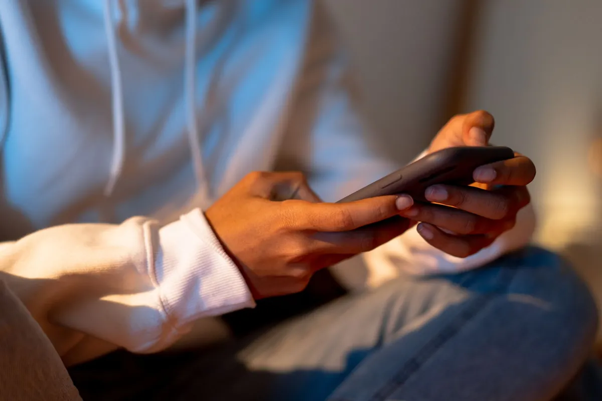 Hands holding a smartphone in warm evening light, searching for help nearby